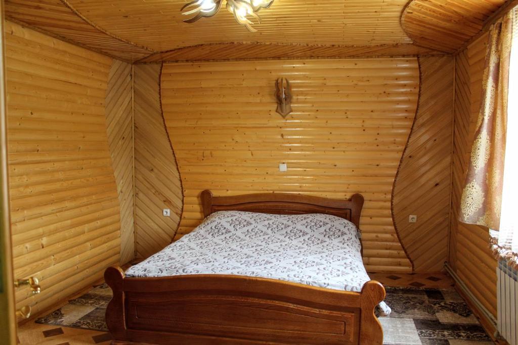 een slaapkamer met een bed in een houten kamer bij Садиба "У Бервінових" in Jaremtsje
