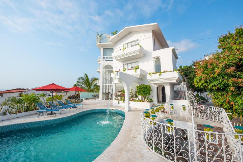 een wit huis met een zwembad ervoor bij La Casa Blanca in Puerto Vallarta