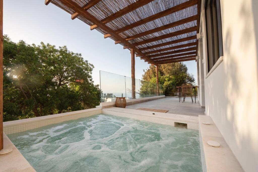 a hot tub in the backyard of a house at forest view villas 2 in Lagoúdi Zía