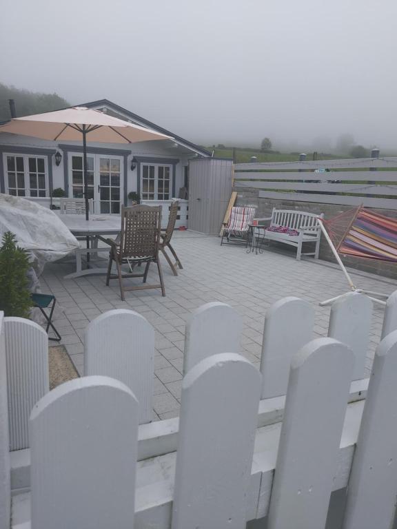 a patio with a table and chairs and an umbrella at Amberley in Gorey