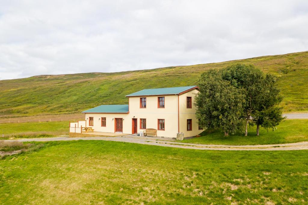 una casa en medio de un campo de hierba en Langavatn Guesthouse, en Aðaldalur