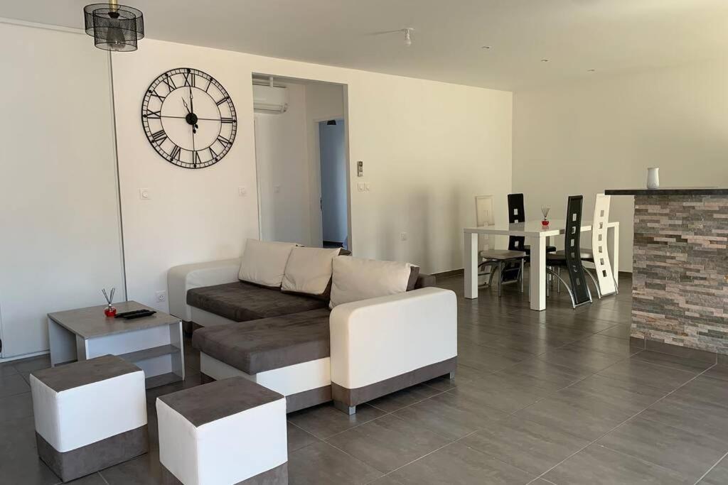 un salon avec un canapé et une horloge au mur dans l'établissement Maison de l’occitanie, à Bessan