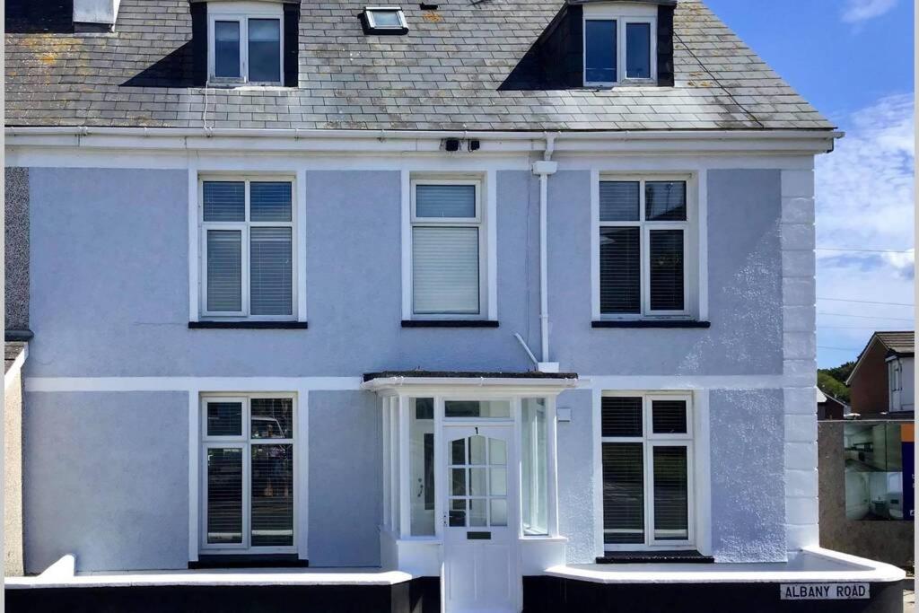 a white house with white doors and windows at Large 5 bed 3 bath house 300 meters from beach and restaurants in Newquay
