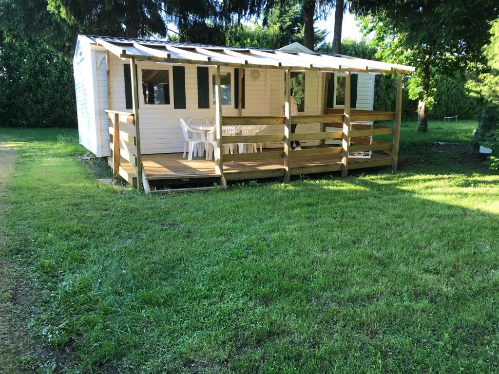 uma pequena casa com um alpendre e uma mesa em Charmant Mobil Home 6 personnes avec clim réversible em Boofzheim