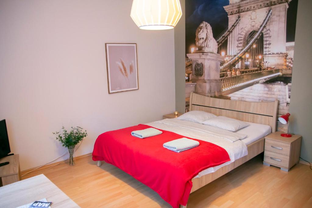 a bedroom with a bed with a red blanket at Keleti Aparthotel in Budapest