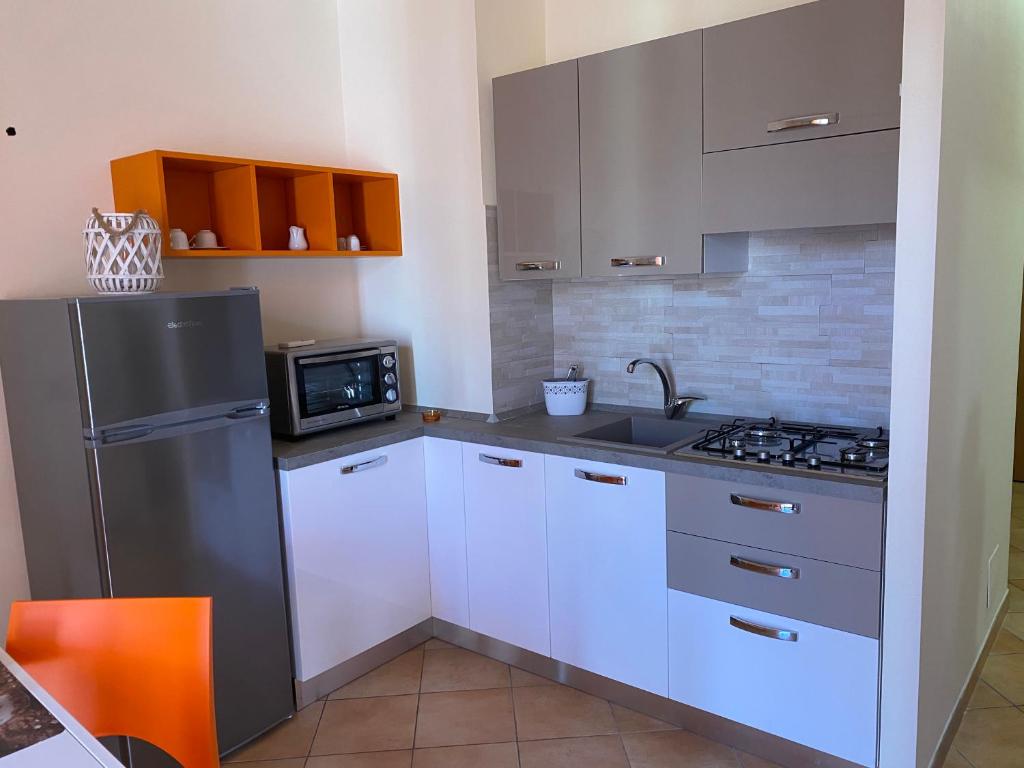 W kuchni znajduje się lodówka ze stali nierdzewnej i kuchenka mikrofalowa. w obiekcie Casette Tulipano w mieście Santa Teresa di Riva