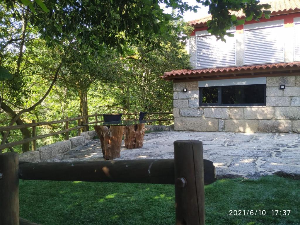 a fence in front of a house with a yard at Casa das Andorinhas in Póvoa de Lanhoso