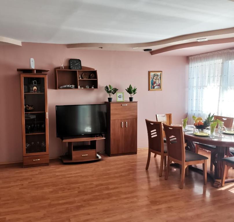 a living room with a television and a table with chairs at Central Apartment Targovishte in Targovishte