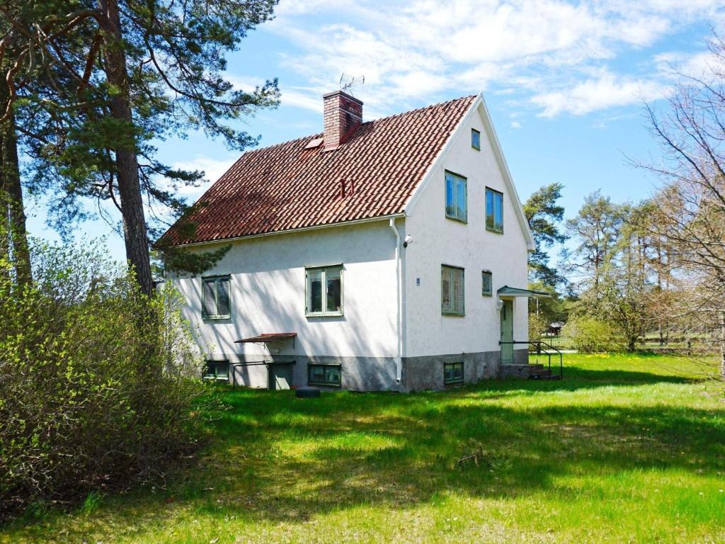 una gran casa blanca con techo rojo en 4 person holiday home in ST NGA, en Stånga
