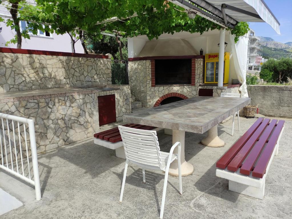 una mesa y sillas de madera y una chimenea de piedra en Villa Radić, en Makarska