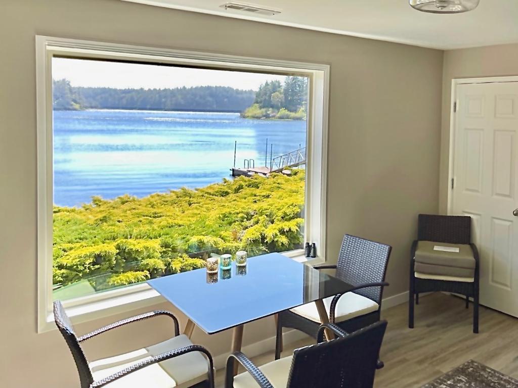 een eetkamer met een groot raam met een tafel en stoelen bij Apartment at Floras Lake Getaway in Langlois