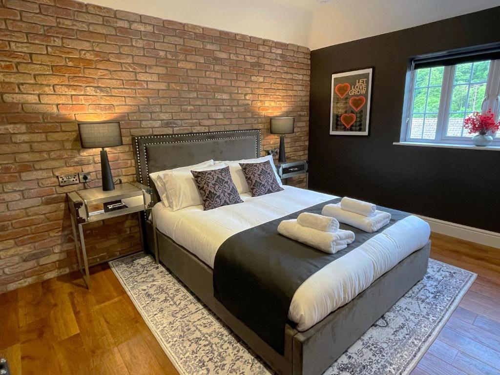 a bedroom with a large bed with a brick wall at 'The Loft' in Yeovil