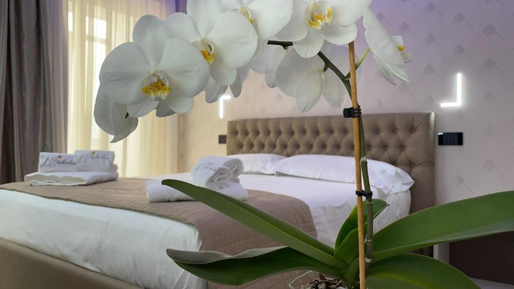 a bedroom with a bed with white flowers on it at B&B L'Orchidea in Tropea