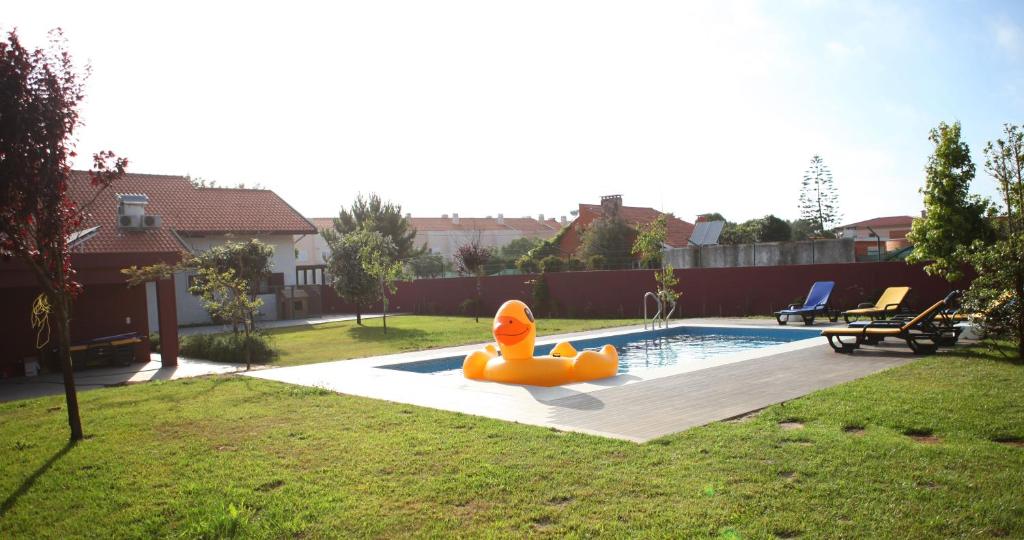 a pool with an inflatable rubber duck in a yard at Woof & Sun in Esmoriz