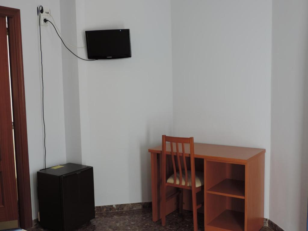 a room with a desk and a television on a wall at Hotel Costa San Antonio in Cullera