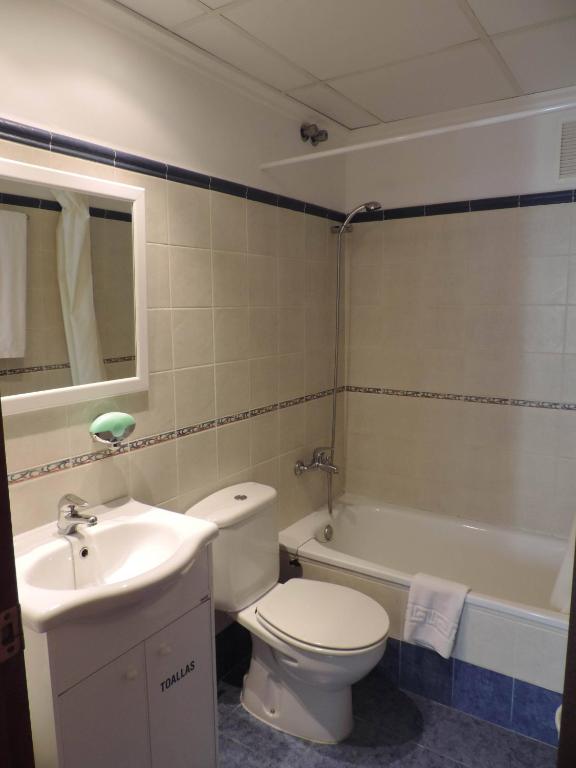 a bathroom with a toilet and a sink and a tub at Hotel Costa San Antonio in Cullera