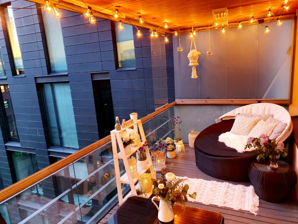 a balcony with a bed and a table and lights at 2ndhomes Unique and Luxury Kamppi Center Apartment with Sauna and Big Terrace in Helsinki