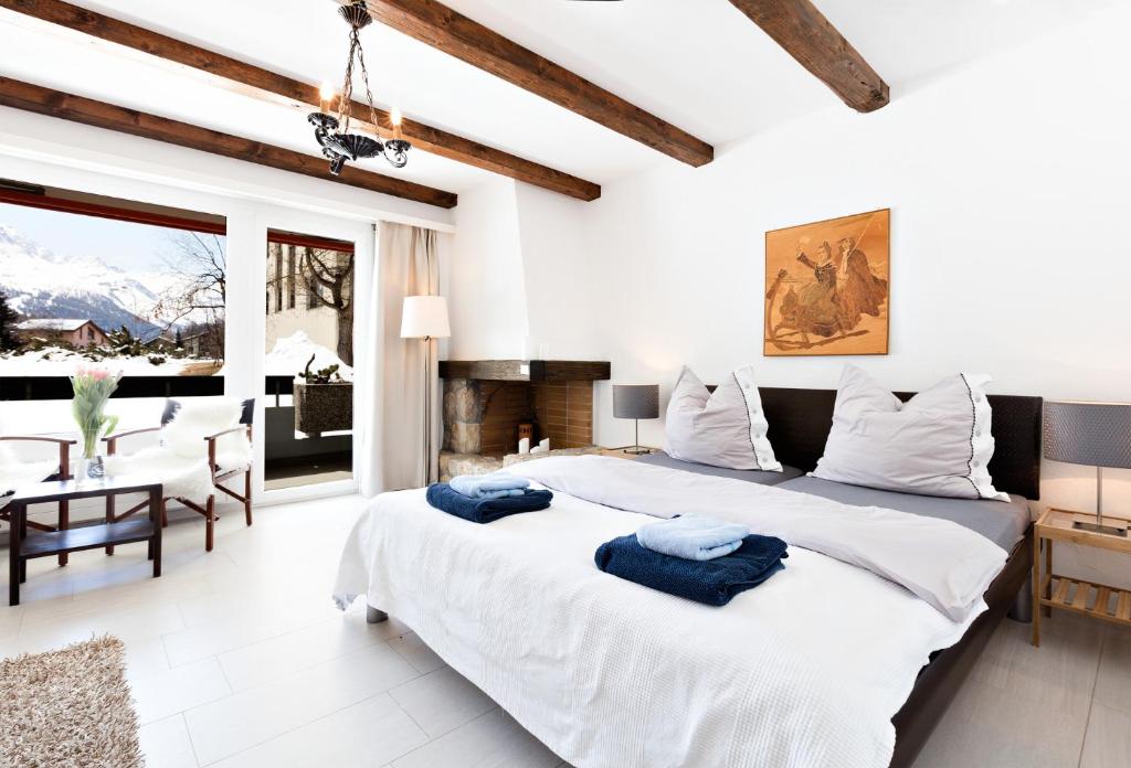 1 dormitorio blanco con 1 cama grande y chimenea en Gemütliches Studio in Champfèr/St.Moritz en St. Moritz