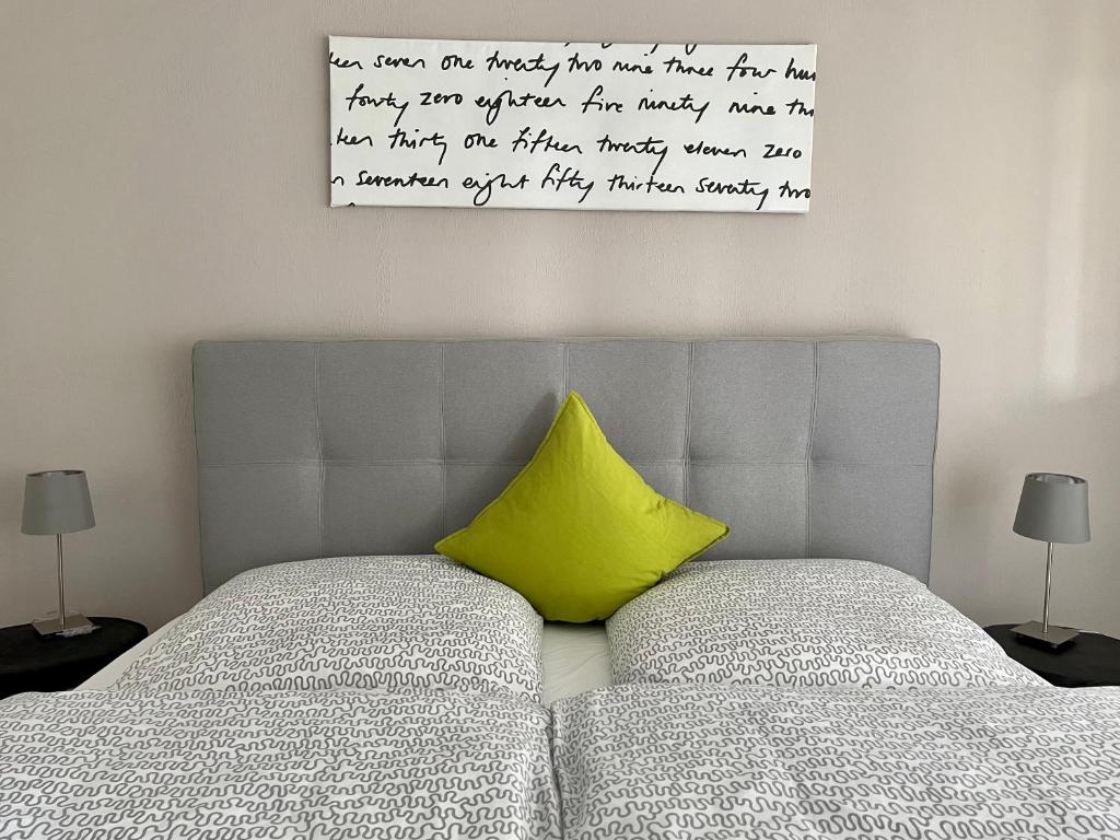 a yellow pillow sitting on top of a bed at Black Forest Guest Stay in Pfalzgrafenweiler