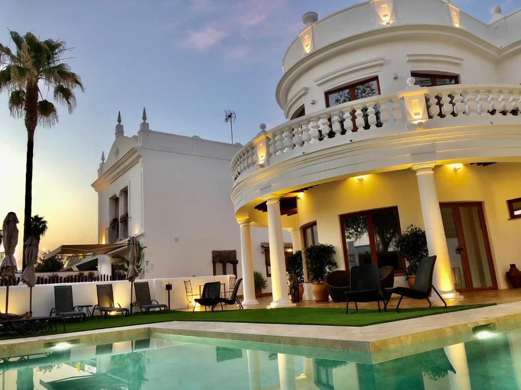 una grande casa bianca con una piscina di fronte di La Quinta Hacienda a Cordoba