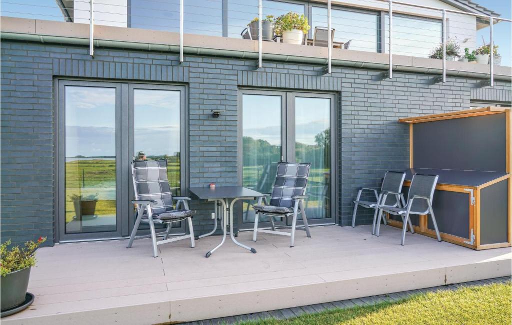 d'une terrasse avec des chaises, une table et un paravent. dans l'établissement Amazing Apartment In Kappeln With House Sea View, à Kappeln