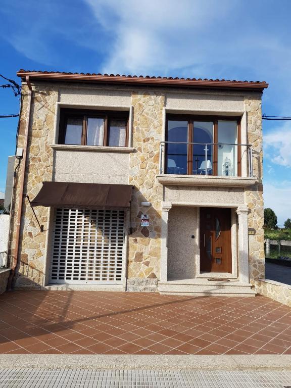 a large stone house with a large window at El Rincón de Cambados in Cambados