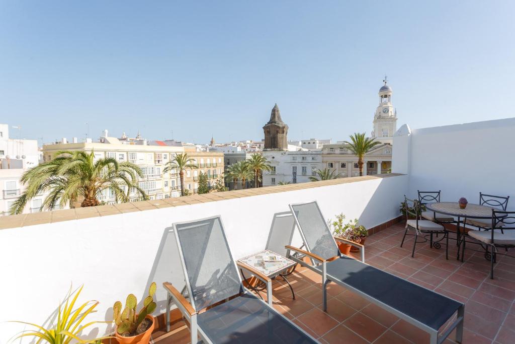 einen Balkon mit Stühlen und einem Tisch auf einem Gebäude in der Unterkunft Atico-Solarium CITY Hall by Cadiz4Rentals in Cádiz