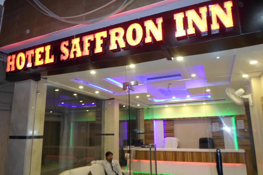 a man sitting on a couch in front of a hotel station inn at Hotel Saffron Inn in New Delhi