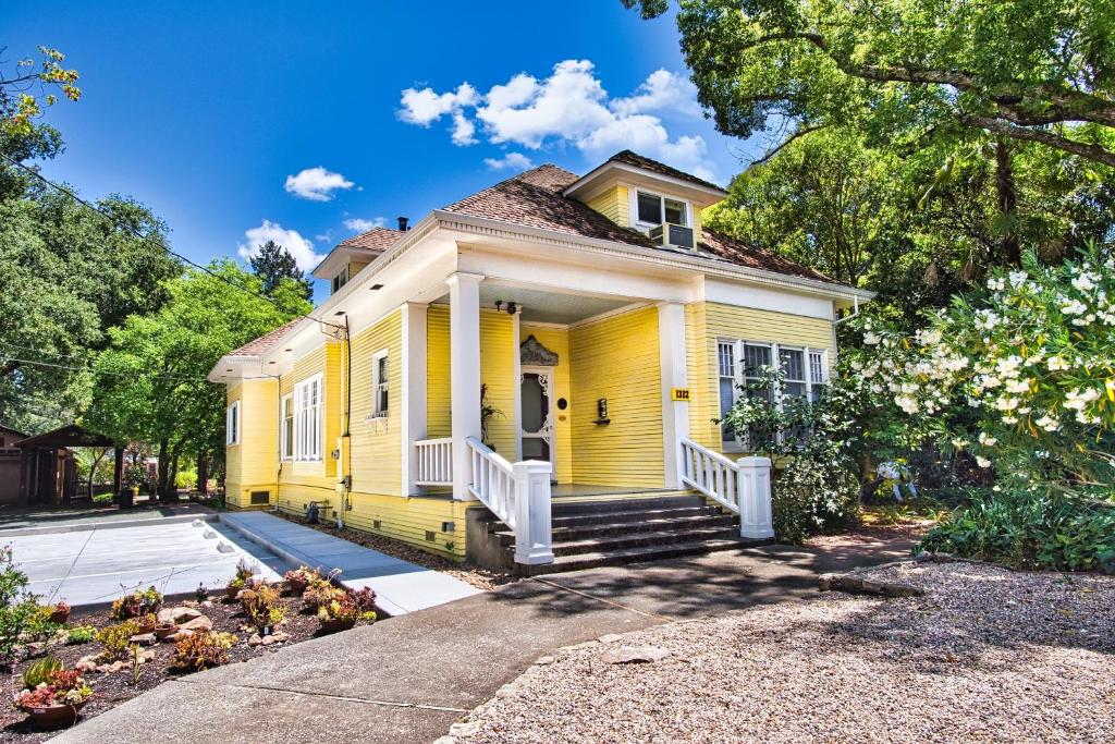 żółty dom z gankiem i podjazdem w obiekcie Regal Victorian Home in Downtown Calistoga w mieście Calistoga