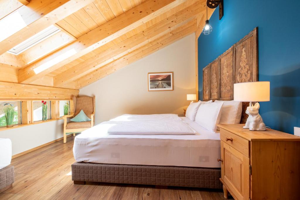 1 dormitorio con 1 cama grande y techo de madera en Haus Ludwig Alpenkrähe, en Garmisch-Partenkirchen