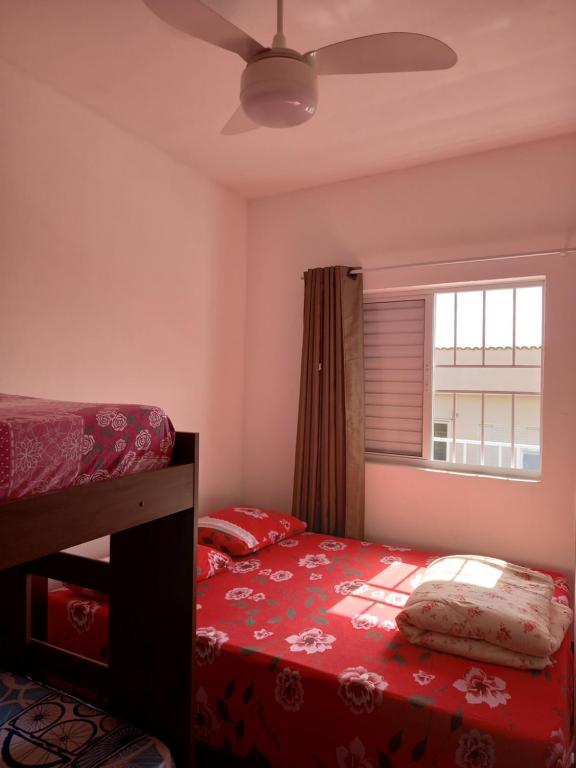een slaapkamer met een bed en een raam bij Apartamento Avenida 01 in São Thomé das Letras