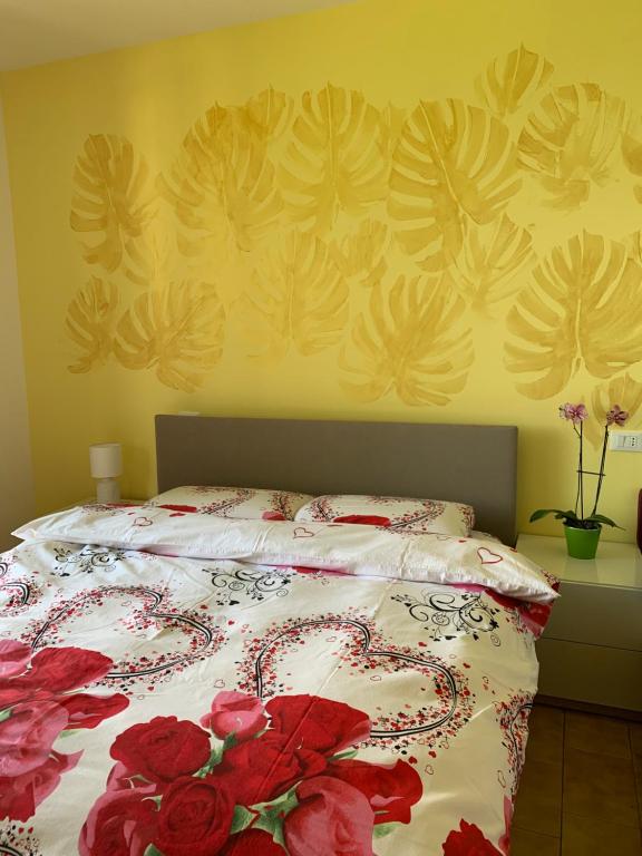 ein Schlafzimmer mit einem Bett mit roten Blumen darauf in der Unterkunft Casanova Sirmione in Sirmione