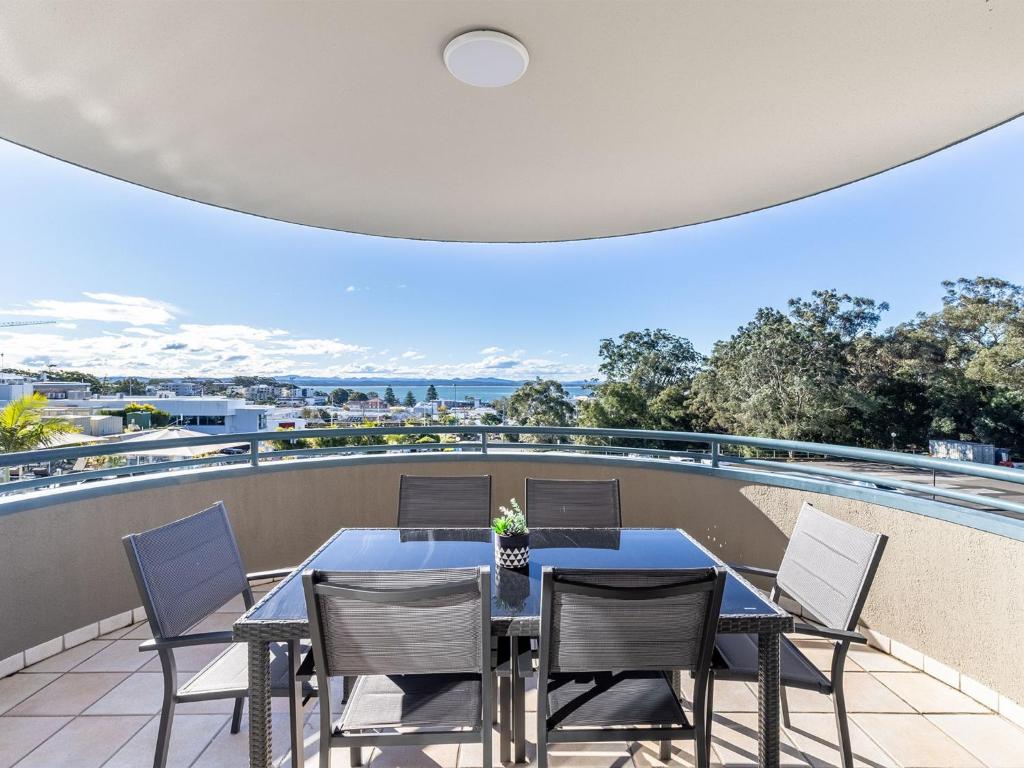 a patio with a table and chairs on a balcony at The Landmark 211 Resort Style holiday with pool games room and restaurant in Nelson Bay