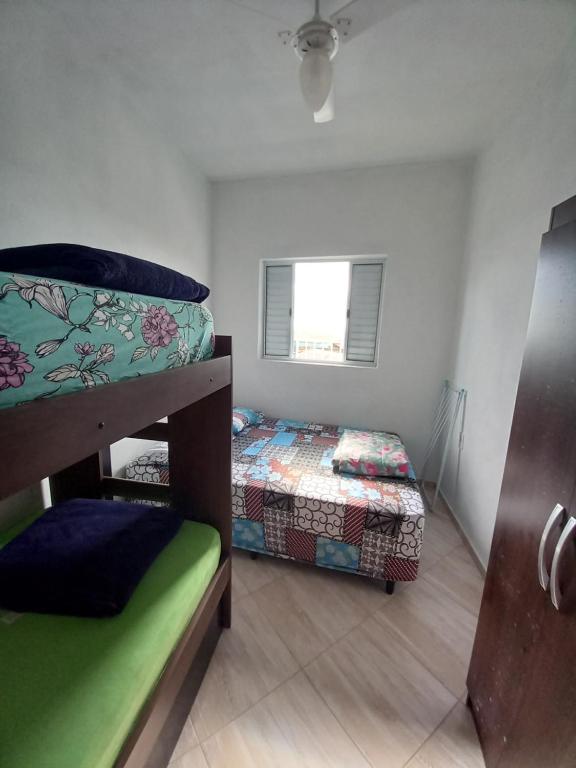a bedroom with two bunk beds and a window at Apartamento avenida 07 in São Thomé das Letras