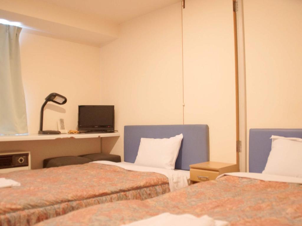 Postel nebo postele na pokoji v ubytování Business Hotel Chateau Est Takamatsu