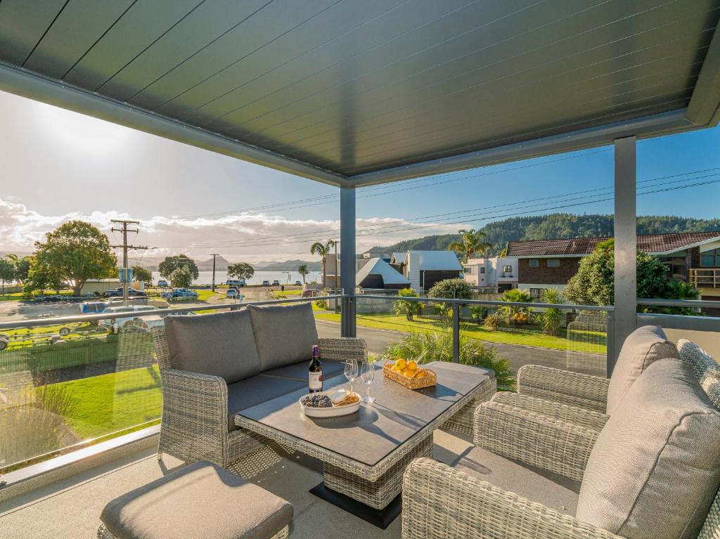 d'une terrasse avec une table et des chaises sur un balcon. dans l'établissement Harbour View - Whangamata Holiday Home, à Whangamata