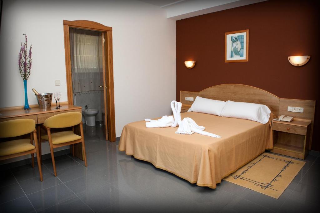 a hotel room with a bed with two towels on it at Hotel Brisa da Lanzada in A Lanzada