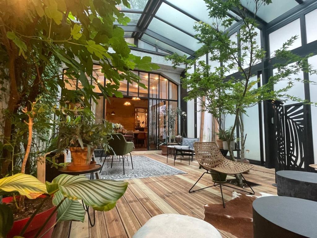 un salón acristalado con plantas, mesas y sillas en Casa Blanca B&B, en Burdeos