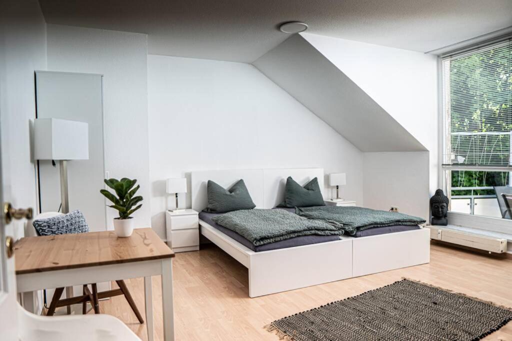 - une chambre blanche avec un lit et une table dans l'établissement Gemütliche Ferienwohnung im Zentrum von Plauen, à Plauen