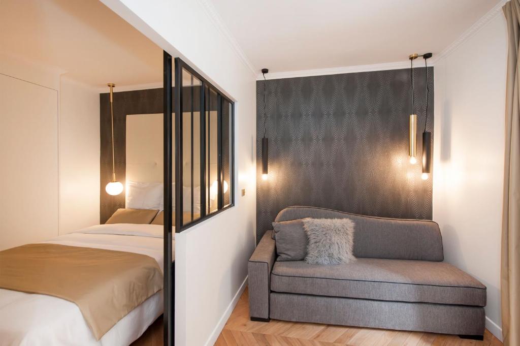 1 dormitorio pequeño con 1 cama y 1 silla en Odéon - Notre Dame Paris Climatisé-Wifi en París