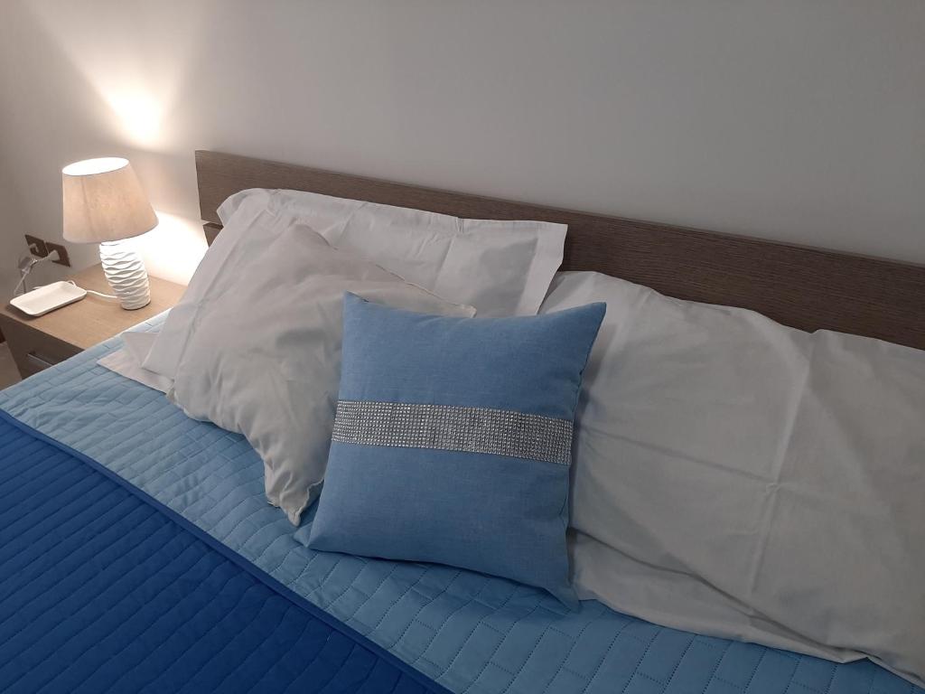 ein Bett mit blauen und weißen Kissen darauf in der Unterkunft URBANFLAT SALENTO in Lecce