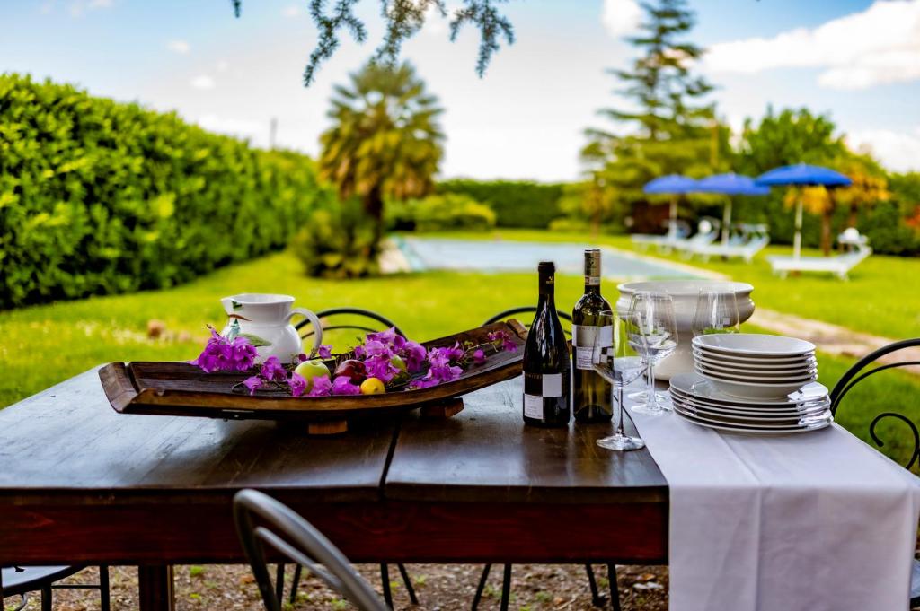 stół z talerzem jedzenia i butelkami wina w obiekcie Il Leccio w mieście San Gimignano
