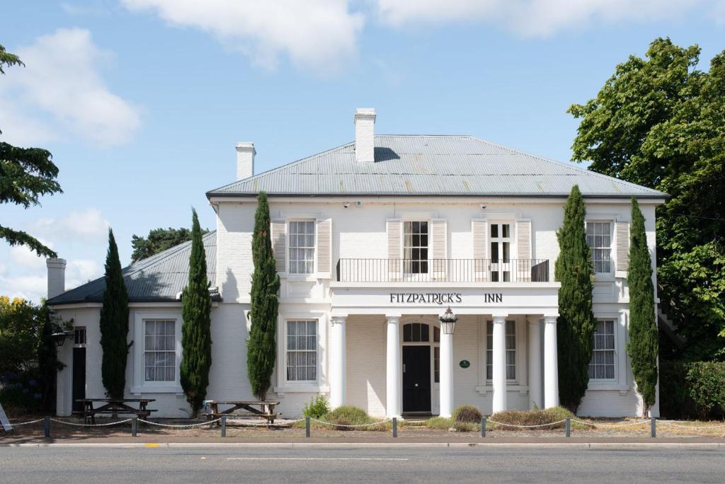 a white house with a sign for the harvard inn at Fitzpatricks Inn in Westbury