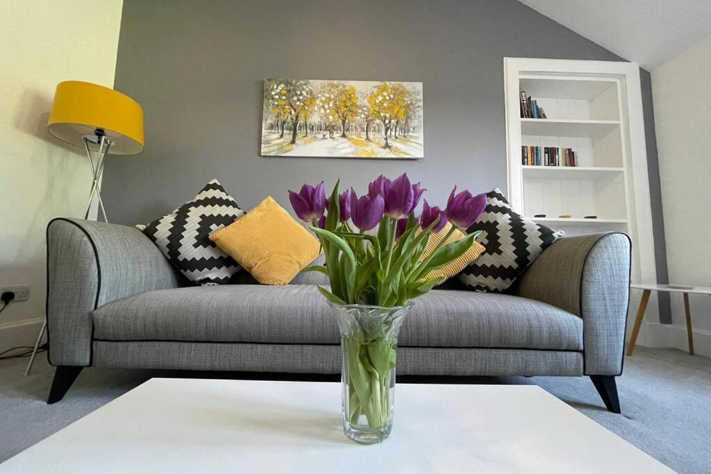 um vaso de flores roxas numa mesa numa sala de estar em No 10 Immaculate City Centre, Top Floor 2 Bed Flat with Free Parking em Inverness