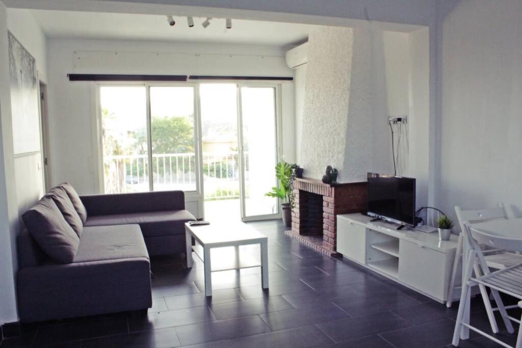 ein Wohnzimmer mit einem Sofa und einem TV in der Unterkunft Precioso Apartamento Los Álamos Playa Golf in Torremolinos