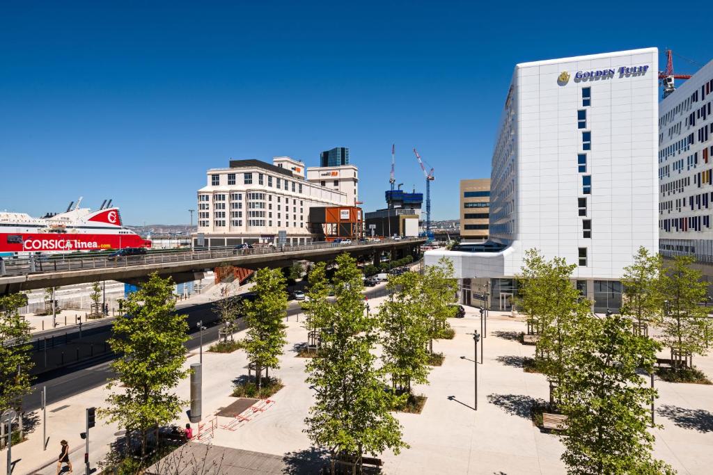 a city with a bridge and trees and buildings at Golden Tulip Marseille Euromed in Marseille