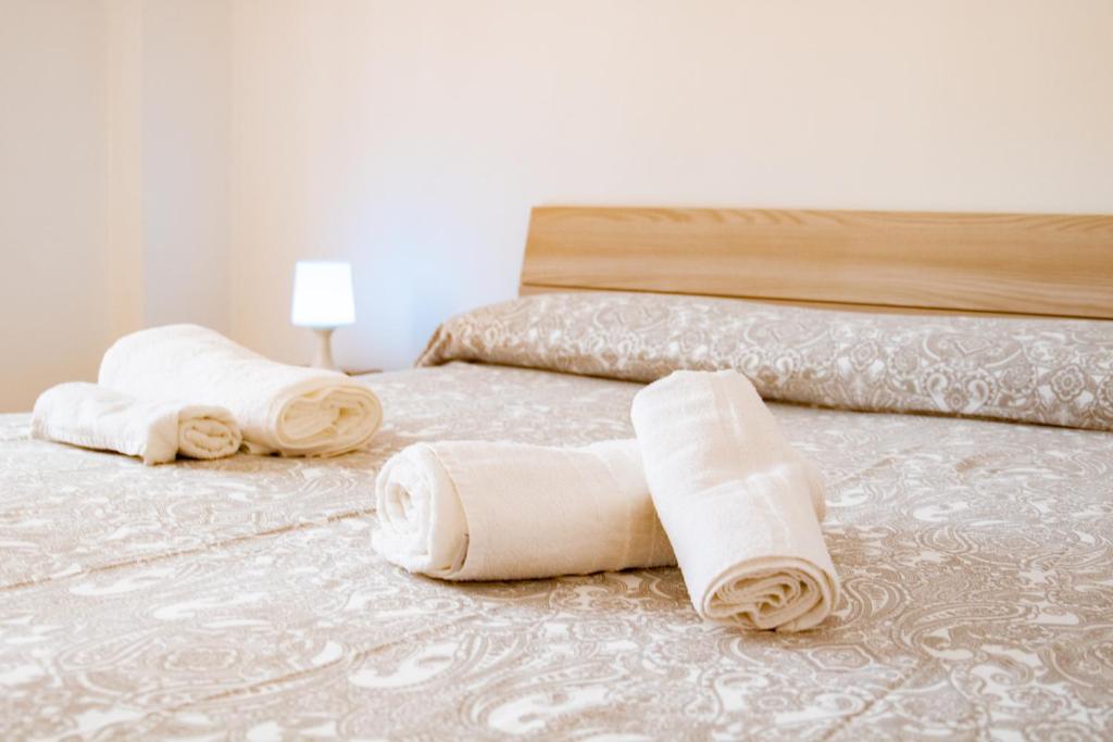 3 toallas enrolladas en una cama en un dormitorio en La casa di Polignano- locazione turistica, en Polignano a Mare
