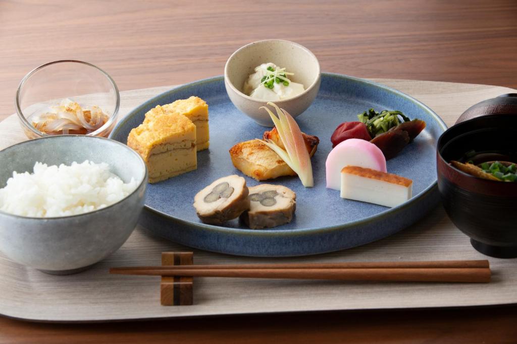a plate of food with sushi and rice and chopsticks at Nikko Style Nagoya in Nagoya
