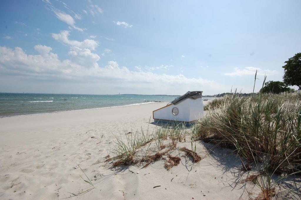 una pequeña cabaña en una playa junto al océano en Schlafstrandkorb Nr. 3 en Sierksdorf