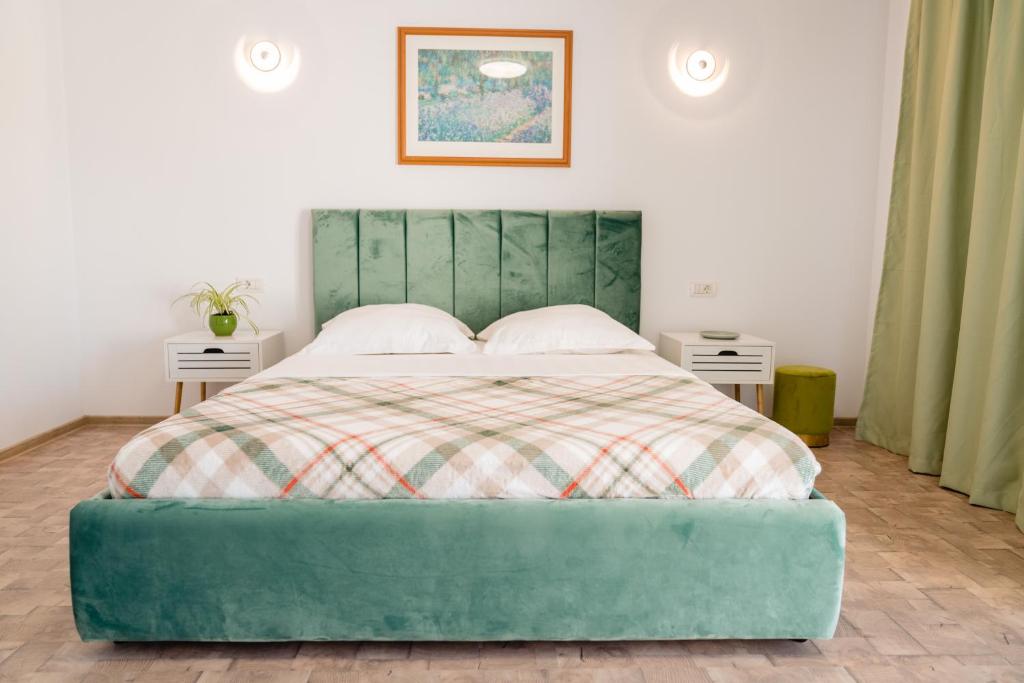 uma cama com uma cabeceira de cama verde num quarto em Wait`N Sea House em Tuzla